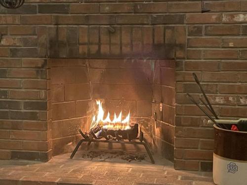 a brick fireplace with a fire in it at Bear Pass - Mountain View home in Sunderland