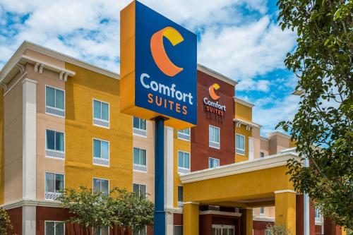 a sign in front of a building with a hotel at Comfort Suites Denham Springs in Denham Springs