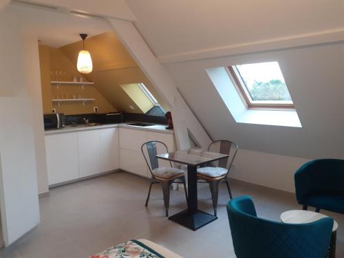 une cuisine et une salle à manger avec une table et des chaises dans l'établissement Le plan d'eau, à Civray-de-Touraine