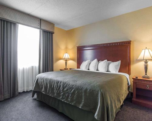 a hotel room with a large bed and a window at Quality Inn & Suites Bay Front in Sault Ste. Marie