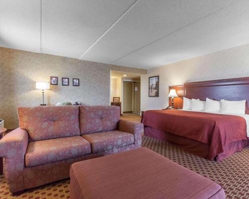 a hotel room with a bed and a couch at Quality Inn & Suites Bay Front in Sault Ste. Marie