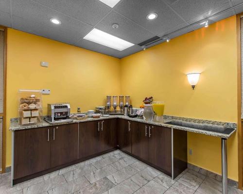 a kitchen with yellow walls and a counter with food at Quality Inn & Suites Bay Front in Sault Ste. Marie