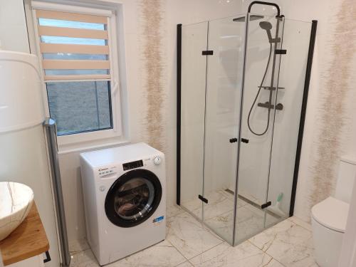 a washing machine in a bathroom with a shower at Aura Roztocze - Domek z balią przy lesie in Zamość