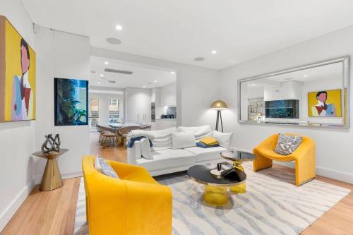 a living room with a white couch and yellow chairs at Luxurious 3-Story Terrace in Potts Point in Sydney