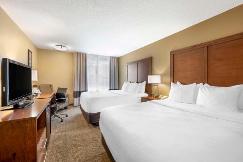 a hotel room with two beds and a flat screen tv at Comfort Inn Lexington in Lexington