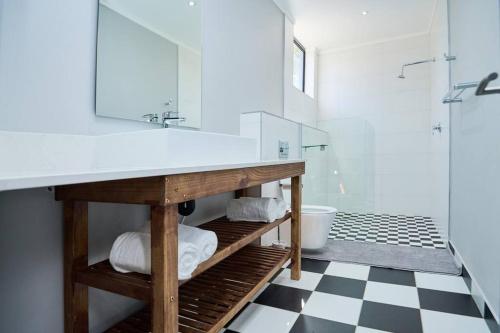 a white bathroom with a sink and a mirror at Brooklyn Modern Apartment in Pretoria