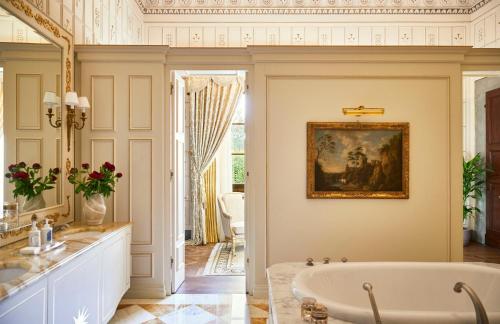 a bathroom with a tub and a painting on the wall at Four Seasons Hotel Firenze in Florence