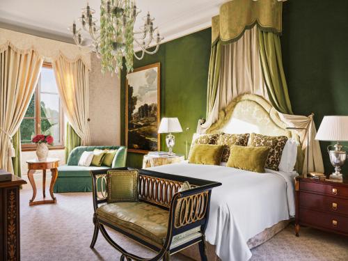 a bedroom with a bed and a chair and a chandelier at Four Seasons Hotel Firenze in Florence