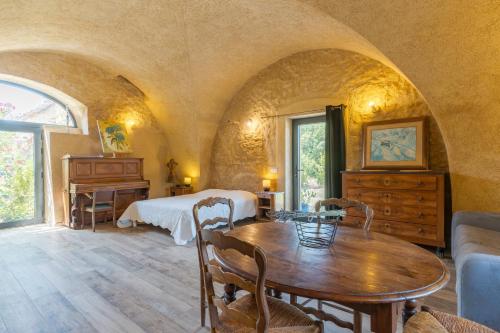a room with a bed and a table in a room at L'Amaryflor in Vaugines