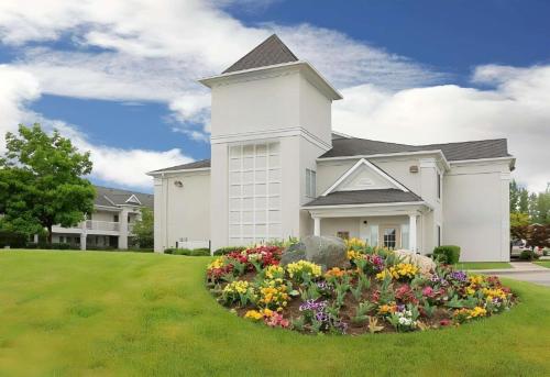 a large white house with flowers in the yard at Studio 6 - Murray, UT in Murray