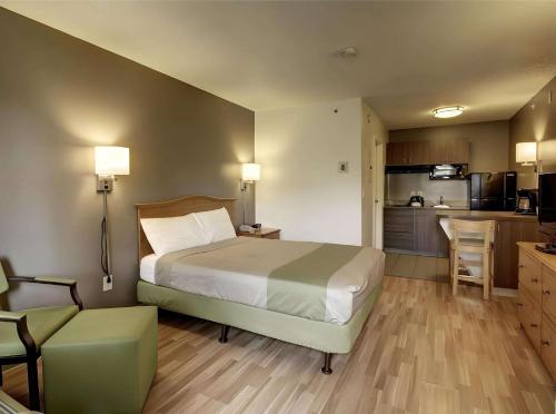 a bedroom with a large bed and a kitchen at Studio 6 - Murray, UT in Murray