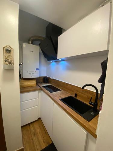 une petite cuisine avec des armoires blanches et un évier dans l'établissement L'Oustalet, à Nice