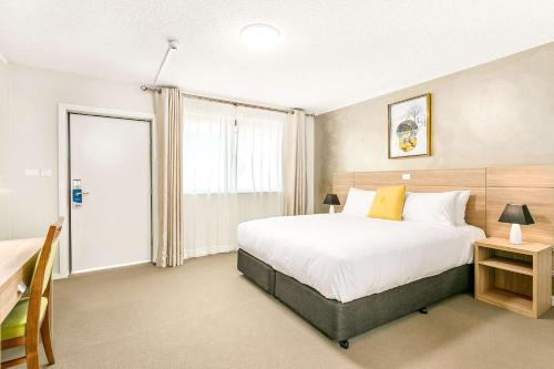 a bedroom with a large bed and a window at Quality Inn Sunshine Haberfield in Sydney