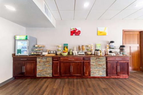 a kitchen with wooden cabinets and a counter top at Quality Inn & Suites Vandalia near I-70 and Hwy 51 in Vandalia