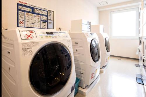 a laundry room with two washing machines on display at Comfort Hotel Kochi in Kochi