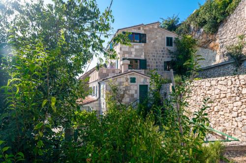 a stone house on top of a stone wall at Apartments with pool Maraska in Brela