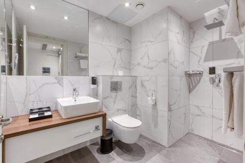 a bathroom with a sink and a toilet and a shower at Solana Hotel & Spa in Mellieħa