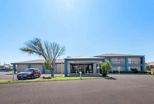 un bâtiment avec une voiture garée devant dans l'établissement Quality Inn, à Plainview