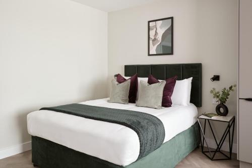 a bedroom with a large bed with red pillows at London City East by Viridian Apartments in London