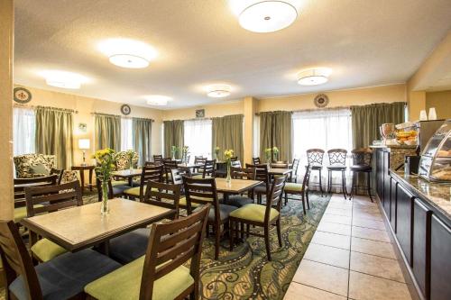 un restaurant avec des tables et des chaises en bois et des fenêtres dans l'établissement Clarion Inn & Suites Aiken South, à Aiken
