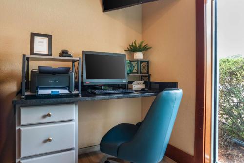 a desk with a computer and a blue chair at Comfort Inn & Suites in Crestview