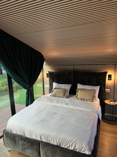 a bedroom with a large bed with a large window at Guesthouse Prrockaj Theth in Theth