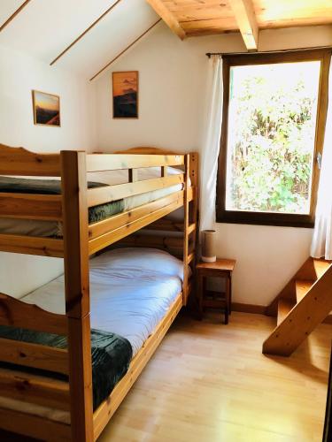 deux lits superposés dans une chambre avec fenêtre dans l'établissement Gîte La Grange au Bois, à Viella
