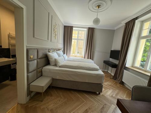 a bedroom with a bed and a desk and windows at Residenz Hugo in Bad Schandau