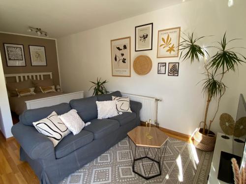 a living room with a blue couch and a table at Stilvolles Appartement in Jena