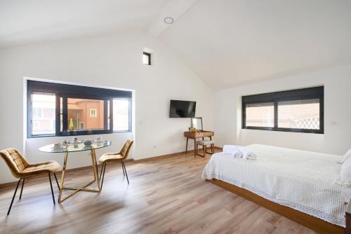 a bedroom with a bed and a table and chairs at Casa do Moleiro in Mortágua