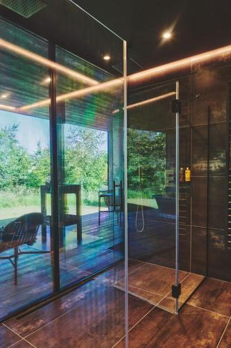 a glass pivot door in a house with a patio at Whispering Leaves in Glastonbury