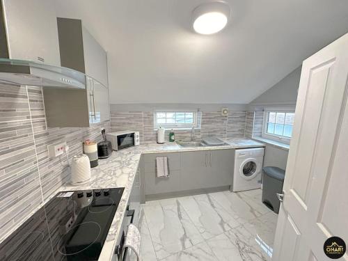 a large kitchen with a stove and a washing machine at Modern 1 Bed Apartment In Morpeth - Contractors in Morpeth