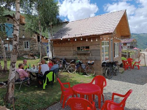 a group of people sitting at a table in front of a building at Guest House Cafe Nita in Ushguli