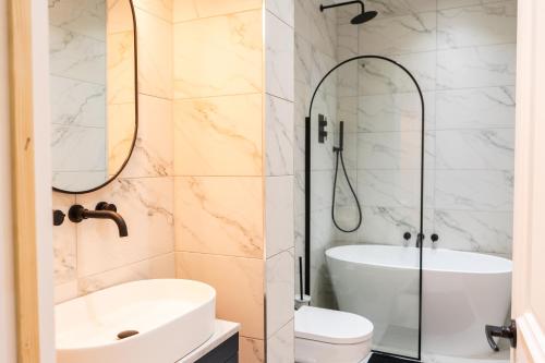 a bathroom with a shower and a sink and a toilet at Kensington Bay View Dreams in London