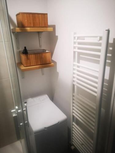 une petite cuisine avec un réfrigérateur et des étagères en bois dans l'établissement Appart dans le centre historique de Chartres, à Chartres