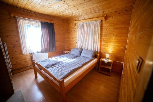 a bedroom with a bed in a wooden cabin at Vivien vendégház in Borzont