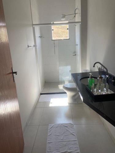 ein Badezimmer mit Dusche, Toilette und Waschbecken in der Unterkunft Evidence Hotel in Sapucaia