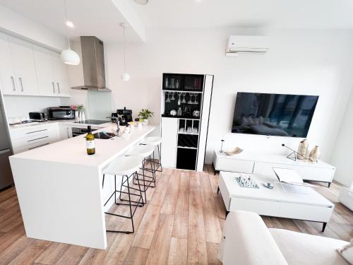 a kitchen with white cabinets and white counter tops at Luxury 2 Bedroom Apartment with cocktail bar and espresso machine in Auckland