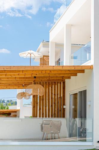 a patio with a table and a chair on a house at Serenity Hill in Paliouri