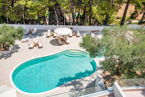 an overhead view of a swimming pool with a table and umbrella at Serenity Hill in Paliouri