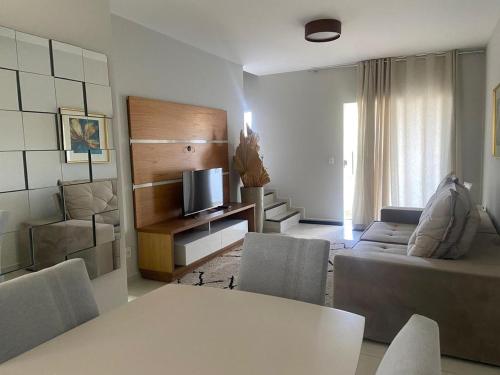 a living room with a couch and a tv at Evidence Hotel in Sapucaia