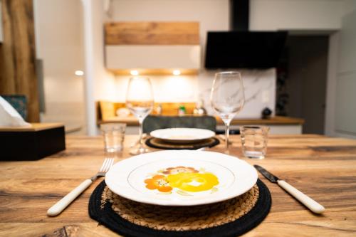 une table en bois avec une assiette d'œufs dessus dans l'établissement Charmant 2P au Cœur d'Haguenau, à Haguenau