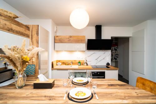 une cuisine avec une table en bois avec des assiettes de nourriture dessus dans l'établissement Charmant 2P au Cœur d'Haguenau, à Haguenau