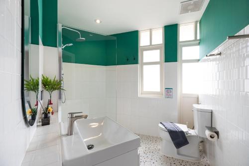 a bathroom with a white toilet and a sink at Belivin99 Residence Chinatown in Bangkok