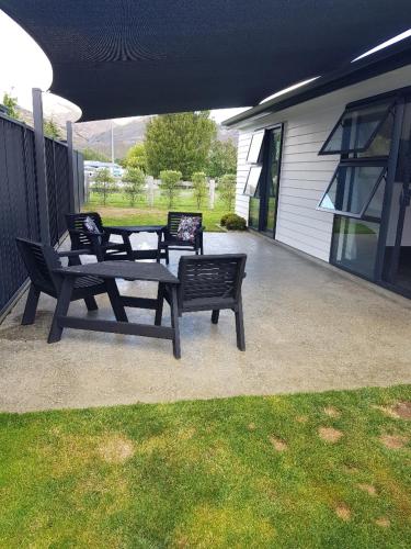 two benches sitting on a patio next to a house at Modern Family Pad In Cromwell in Cromwell