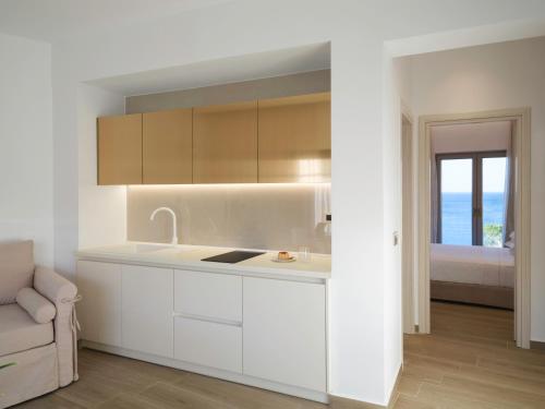 a kitchen with white cabinets and a view of the ocean at Golden Luxury Suites in Balíon