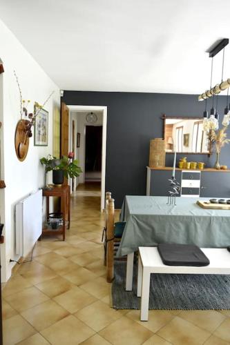 une salle à manger avec une table et un mur bleu dans l'établissement Ô bord du Lac - Canoé, barbecue, à Chaumard
