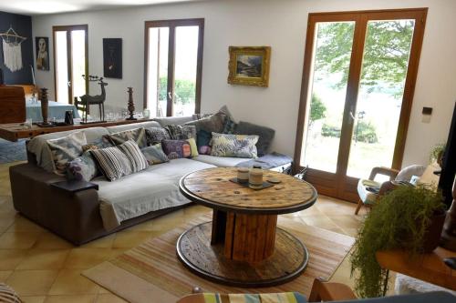 a living room with a couch and a table at Ô bord du Lac - Canoé, barbecue in Chaumard