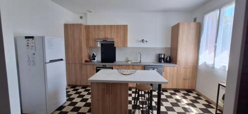 a kitchen with wooden cabinets and a white refrigerator at Issoudun appart élégant 150m² in Issoudun