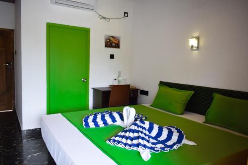 a green and white bed with two pillows on it at Hotel Green Garden in Trincomalee